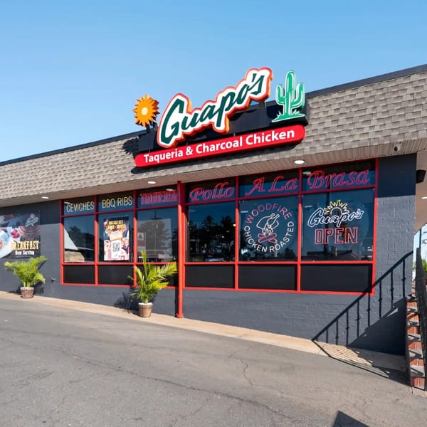 Exterior of Guapo's GO, a Tex-Mex restaurant, with its sign and window advertisements visible.