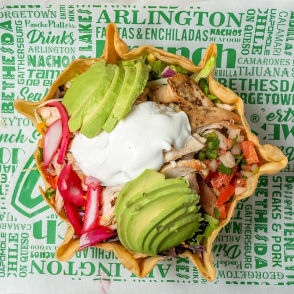 A Guapo's GO taco salad with chicken, avocado, sour cream, and pico de gallo in a crispy shell.