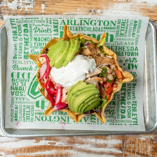 A Guapo's GO taco salad in a crispy shell with chicken, avocado, sour cream, and pico de gallo.