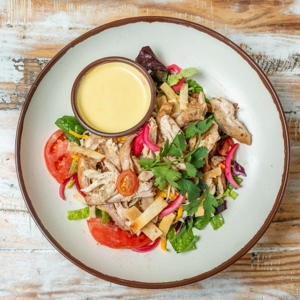 Guapo's GO chicken salad with tomatoes, pickled onions, tortilla strips, cilantro, and dressing.