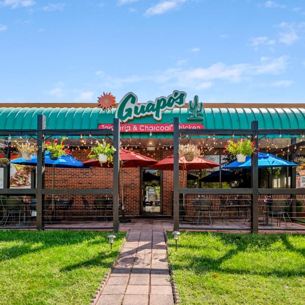 Guapo's Taquería & Charcoal Chicken exterior with outdoor patio seating, umbrellas, and string lights.